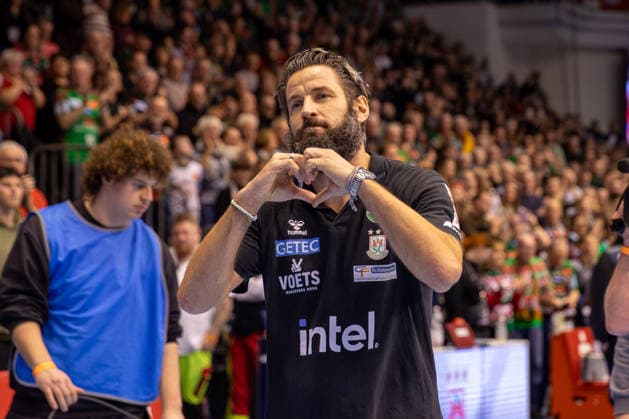 21.12.2025, xgox, Handball - Daikin HBL SC Magdeburg - SC DHfK Leipzig emspor, v.l. Bennet Wiegert (Magdeburg, Trainer) wird für 10 Jahre beim SC Magdeburg von den Fans geehert, zeigt ein Herz Magdeburg