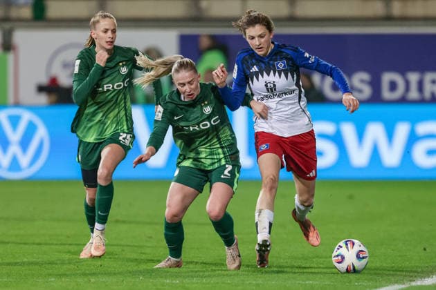 v.li.: Vivien Endemann (VfL Wolfsburg, 25), Thea Bjelde (VfL Wolfsburg, 2) und Lotta Wrede (Hamburger SV, 32) im Zweikampf, Duell, Dynamik, Aktion, Action, Spielszene, DIE DFB-RICHTLINIEN UNTERSAGEN JEGLICHE NUTZUNG VON FOTOS ALS SEQUENZBILDER UND ODER VIDEOÄHNLICHE FOTOSTRECKEN. DFB REGULATIONS PROHIBIT ANY USE OF PHOTOGRAPHS AS IMAGE SEQUENCES AND OR QUASI-VIDEO., 21.12.2025, Wolfsburg (Deutschland), Fussball, Google Pixel Frauen-Bundesliga, VfL Wolfsburg - Hamburger SV