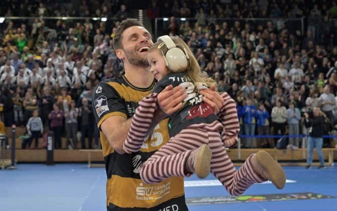 21.12.2025, Dresdens Sebastian Greß mit Tochter Amalia nach dem Sieg, Handball, 2. Bundesliga, HC Elbflorenz Dresden - TV Großwallstadt, (c) Dresden