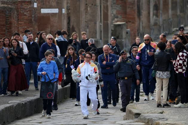 Pompei: December 22, 2025, Milan-Cortina 2026 Winter Olympics. The photo shows the Olympic torch passing through the Archaeological Park. Actor Jackie Chan  Copyright: xAlessandroxGarofalo LaPressex