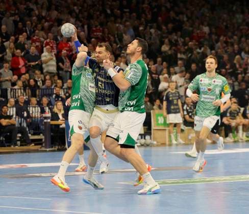 Foto : Torwurf von .... Casper MORTENSEN (HSV) gegen Matthes Langhoff (Füchse) und rechts ... Mijajlo Marsenic (Füchse) Handball Herren 1. Bundesliga am Di. 23.12.2025 HSV Handball - Füchse Berlin