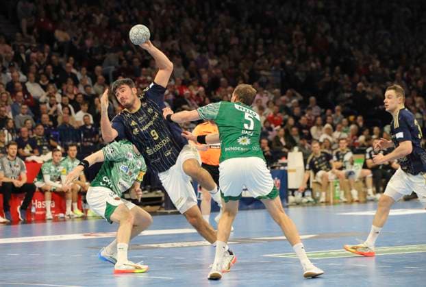 Foto : Torwurf von ..... Jacob Arenth LASSEN (HSV) gegen Matthes Langhoff (Füchse)(Füchse) und rechts ... Max DARJ (Füchse) Handball Herren 1. Bundesliga am Di. 23.12.2025 HSV Handball - Füchse Berlin