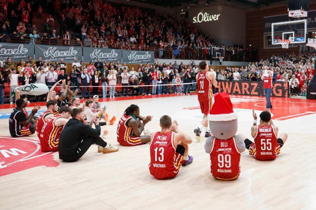 v. l. n. r.: Die Würzburger Spieler um MVP Brae Ivey (Fitness First Wuerzburg Baskets, 11) feiern mit den Fans. 26.12.2025, Basketball, BBL, Fitness First Wuerzburg Baskets vs. VET-CONCEPT Gladiators Trier, GER, Wuerzburg, Tectake Arena. Copyright: HMBxMedia xHeikoxBecker