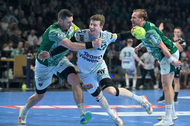 27.12.2025, xlakx, Handball Daikin HBL, Fuechse Berlin - FRISCH AUF! Göppingen v.l. Mijajlo Marsenic (Fuechse Berlin), Erik Persson (FRISCH AUF! Goeppingen), Max Darj (Fuechse Berlin) Zweikampf, Duell, Kampf, tackle Berlin