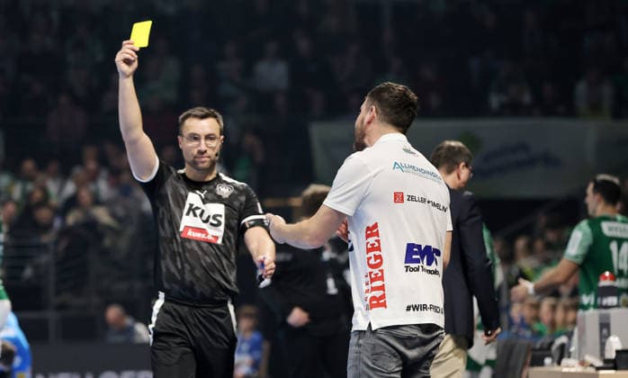Schiedsrichter Steven Heine zeigt gelbe Karte für Trainer Ben Matschke Handball HBL Bundesliga Herren 19. Spieltag Saison 2025 2026 27.12.2025 Füchse Berlin vs Frisch Auf Göppingen