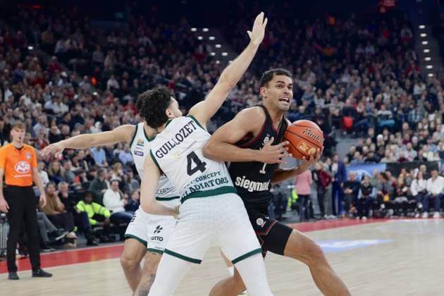 Triers 4 GUILLOZET vs Bayerns 1 Oscar DA SILVA. Basketball: Bayern - Trier. Bundesliga, FC Bayern Basketball - VET-CONCEPT Gladiators Trier, 11.Spieltag, Saison 2025-2026, 28.12.2025, in Muenchen, S A P G A R D E N, Deutschland. Quelle Copyright Credit : Oryk HAIST