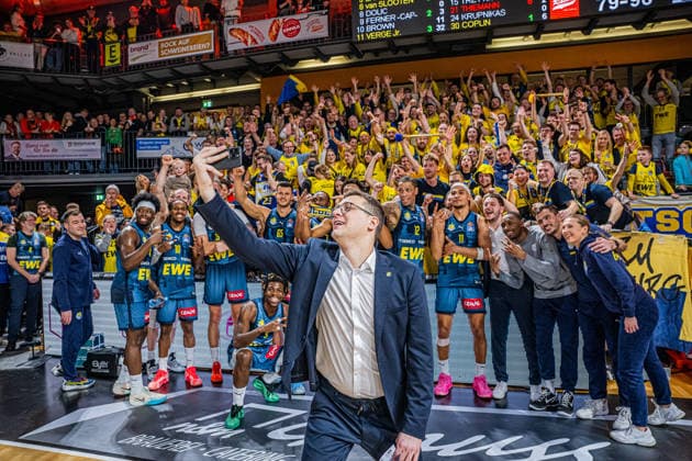 1. Basketball Bundesliga, easyCredit BBL, Saison 2025 2026, Herren, Hauptrunde, 13. Spieltag, 29.12.2025, RASTA Vechta - EWE Baskets Oldenburg Lazar Spasic (Head-Coach - EWE Baskets Oldenburg) beim Siegerselfie mit der Mannschaft und derren Fans Vechta RASTA Dome Niedersachsen Deutschland