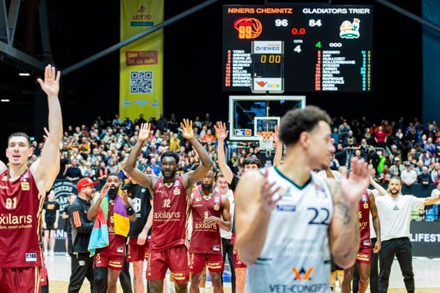 30.12.2025, xomx, Basketball easyCredit BBL Bundesliga, NINERS Chemnitz - VET-Concept Gladiators Trier v.l. Endstand: 96:84. Nolan Adekunle (Gladiators Trier) vorne und hinten feiern die Niners. Yordan Minchev (Niners Chemnitz), Amadou Sow (Niners Chemnitz) Chemnitz