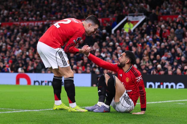 Football - Premier League - Manchester United, ManU v Wolverhampton Wanderers 30th December 2025 - Premier League - Manchester United v Wolverhampton Wanderers - Diogo Dalot of Manchester United (L) helps Matheus Cunha of Manchester United to his feet - Photo: Simon Stacpoole Offside. Manchester UK Copyright: xSimonxStacpoolexOffside