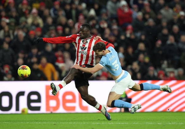 Sunderland, England, 1st January 2026. Brian Brobbey (L) of Sunderland in action with Ruben Dias of Manchester City during the Sunderland vs Manchester City Premier League match at the Stadium Of Light, Sunderland. Picture credit should read: Nigel Roddis Sportimage EDITORIAL USE ONLY. No use with unauthorised audio, video, data, fixture lists, club league logos or live services. Online in-match use limited to 120 images, no video emulation. No use in betting, games or single club league player publications. SPI_016_NR_SUND_MANC SPI-4424-0016