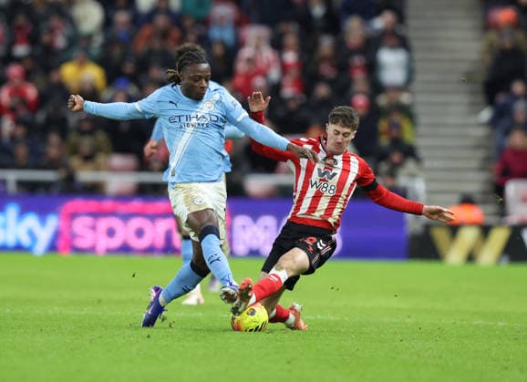 Sunderland, England, 1st January 2026. Trai Hume (R) of Sunderland in action with Jeremy Doku of Manchester City during the Sunderland vs Manchester City Premier League match at the Stadium Of Light, Sunderland. Picture credit should read: Nigel Roddis Sportimage EDITORIAL USE ONLY. No use with unauthorised audio, video, data, fixture lists, club league logos or live services. Online in-match use limited to 120 images, no video emulation. No use in betting, games or single club league player publications. SPI_031_NR_SUND_MANC SPI-4424-0030