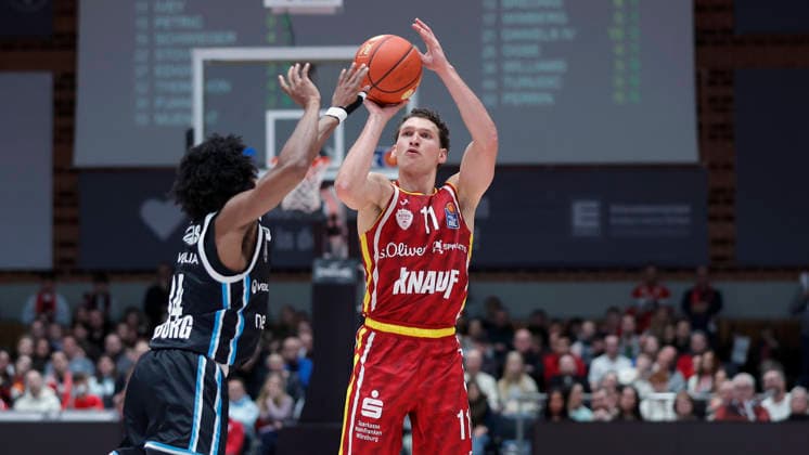 Im Bild: v.li. Ross Williams (Veolia Towers Hamburg, 34) gegen den Dreier von Davion Mintz (Wuerzburg Baskets, 10) 02.01.2026, Fitness First Wuerzburg Baskets vs. Veolia Towers Hamburg, easyCredit BBL, 14. Spieltag, Deutschland, 97072, tectake-Arena Wuerzburg, Copyright: HMBxMedia xJulienxBecker