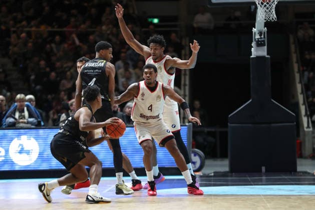 04.01.2026, xgox, Basketball, easyCredit BBL, Basketball Loewen Braunschweig - FC Bayern München emspor, v.l. Xavier Rathan Mayes (Bayern, 4) und David McCormack (Bayern, 33) blocken ihre Gegenspieler Braunschweig