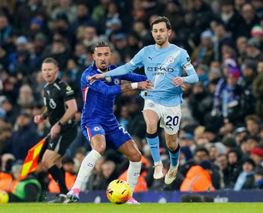 Manchester, England, 4th January 2026. Malo Gusto of Chelsea challenges Bernardo Silva of Manchester City (r) during the Manchester City vs Chelsea Premier League match at the Etihad Stadium, Manchester. Picture credit should read: Andrew Yates Sportimage EDITORIAL USE ONLY. No use with unauthorised audio, video, data, fixture lists, club league logos or live services. Online in-match use limited to 120 images, no video emulation. No use in betting, games or single club league player publications. SPI_043_AY_Man_City_Chelsea SPI-4432-0043