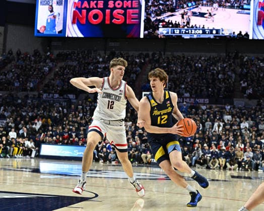 STORRS, CT - JANUARY 04: Marquette Golden Eagles forward Ben Gold (12) handles the ball as UConn Huskies center Eric Reibe (12) defends the play during the game as the Marquette Golden Eagles take on the UConn Huskies on January 04, 2026, at the Gampel Pavilion in Storrs, Connecticut.(Photo by Williams Paul Icon Sportswire) COLLEGE BASKETBALL: JAN 04 Marquette at UConn EDITORIAL USE ONLY Icon26010414370
