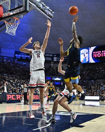 STORRS, CT - JANUARY 04: Marquette Golden Eagles guard Nigel James Jr. (0) shoots the ball as UConn Huskies center Eric Reibe (12) defends during the game as the Marquette Golden Eagles take on the UConn Huskies on January 04, 2026, at the Gampel Pavilion in Storrs, Connecticut.(Photo by Williams Paul Icon Sportswire) COLLEGE BASKETBALL: JAN 04 Marquette at UConn EDITORIAL USE ONLY Icon26010414378