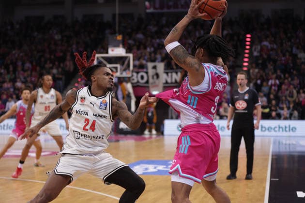 Cobe Williams (Bamberg, L) zieht an Zach Cooks (Bonn), Telekom Baskets Bonn vs Bamberg Baskets, easyCredit BBL, 14. Spieltag, Bonn, 05.01.2026.