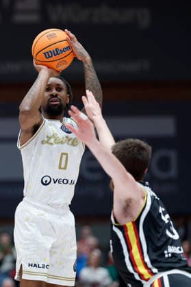 f.l.t.r.: Rickey McGill (Patrioti Levice, 0) with a three against Ryan Schwieger (Fitness First Wuerzburg Baskets, 15), 06.01.2026, Basketball Champions League, Fitness First Wuerzburg Baskets vs. Patrioti Levice, GER, Wuerzburg, Tectake Arena. Copyright: HMBxMedia xHeikoxBecker