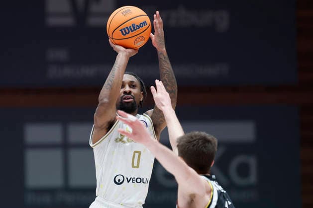 f.l.t.r.: Rickey McGill (Patrioti Levice, 0) with a three against Ryan Schwieger (Fitness First Wuerzburg Baskets, 15), 06.01.2026, Basketball Champions League, Fitness First Wuerzburg Baskets vs. Patrioti Levice, GER, Wuerzburg, Tectake Arena. Copyright: HMBxMedia xHeikoxBecker