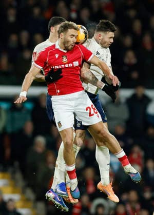 Wrexham, Wales, 9th January 2026. Sam Smith of Wrexham challenged by Morato and Jair Cunha of Nottingham Forest during the Wrexham vs Nottingham Forest FA Cup third round match at the SToK Cae Ras, Wrexham. Picture credit should read: Cody Froggatt Sportimage EDITORIAL USE ONLY. No use with unauthorised audio, video, data, fixture lists, club league logos or live services. Online in-match use limited to 120 images, no video emulation. No use in betting, games or single club league player publications. SPI_040_CF_Wrexham_Forest SPI-4440-0043