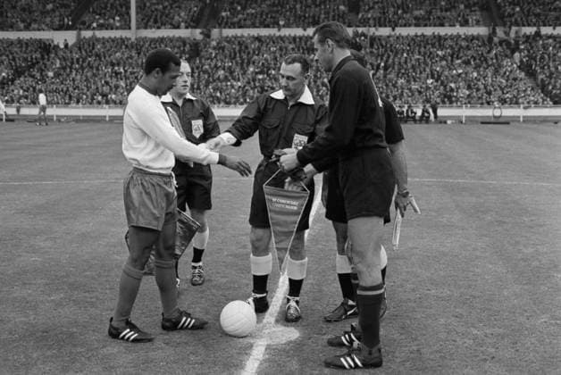 London, United Kingdom. Captain of the Portugal national team, Nationalteam Mario Coluna, referee Ken Dagnall from England and captain of the USSR national team Lev Yashin (L-R front) exchange pennants before the start of the match for 3rd place at the Football World Cup between the Portugal and Soviet Union national teams at Wembley Stadium. The Portuguese won 2:1. Viktor Shandrin TASS  32484260