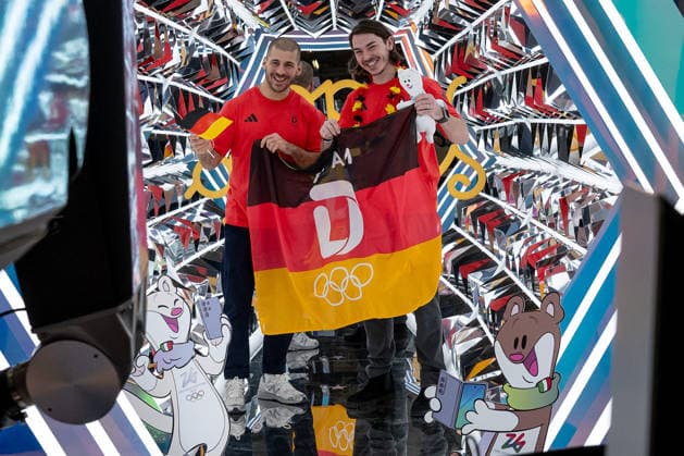 Yasin Ehliz (DOSB-Olympiakader Deutscher Eishockey Bund DEB, Eishockey Nationalmannschaft Herren, Sturm, EHC Red Bull Muenchen) und Daniel Fischbuch (DOSB-Olympiakader Deutscher Eishockey Bund DEB, Eishockey Nationalmannschaft Herren, Sturm, Iserlohn Roosters) beim Videodreh mit Deutschlandfahne GER, DOSB Olympia-Einkleidung Team Deutschland, Mailand Cortina 2026, 12.01.2026. GER, DOSB Olympia-Einkleidung Team Deutschland, Mailand Cortina 2026, 12.01.2026. Muenchen *** Yasin Ehliz DOSB Olympic Squad German Ice Hockey Federation DEB, Ice Hockey National Team Men, Sturm, EHC Red Bull Muenchen and Daniel Fischbuch DOSB Olympic Squad German Ice Hockey Federation DEB, Ice Hockey National Team Men, Sturm, Iserlohn Roosters at the video shoot with the German flag GER, DOSB Olympic Dressing Team Germany, Milan Cortina 2026, 12 01 2026 GER, DOSB Olympic Dressing Team Germany, Milan Cortina 2026, 12 01 2026 Munich Copyright: xEibner-Pressefoto HeikexFeinerx EP_HFR