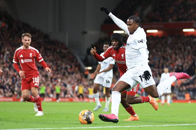 Liverpool, England, 12th January 2026. Reyes Cleary of Barnsley has a shot on goal under pressure from Jeremie Frimpong of Liverpool during the Liverpool vs Barnsley FA Cup match at Anfield, Liverpool. Picture credit should read: Jessica Hornby Sportimage EDITORIAL USE ONLY. No use with unauthorised audio, video, data, fixture lists, club league logos or live services. Online in-match use limited to 120 images, no video emulation. No use in betting, games or single club league player publications. SPI_079_JH_Liverpool_Barnsley SPI-4444-0079