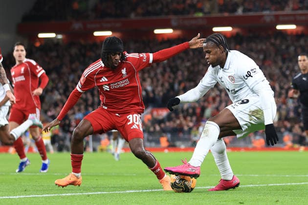 Liverpool, England, 12th January 2026. Jeremie Frimpong of Liverpool and Reyes Cleary of Barnsley challenge for the ball during the Liverpool vs Barnsley FA Cup match at Anfield, Liverpool. Picture credit should read: Jessica Hornby Sportimage EDITORIAL USE ONLY. No use with unauthorised audio, video, data, fixture lists, club league logos or live services. Online in-match use limited to 120 images, no video emulation. No use in betting, games or single club league player publications. SPI_081_JH_Liverpool_Barnsley SPI-4444-0081