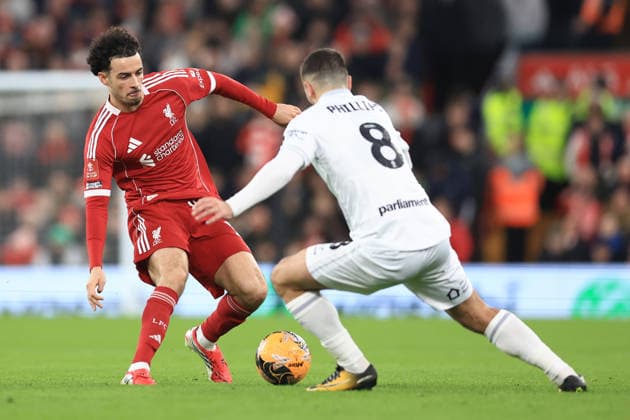 Liverpool, England, 12th January 2026. Curtis Jones of Liverpool and Adam Phillips of Barnsley challenge for the ball during the Liverpool vs Barnsley FA Cup match at Anfield, Liverpool. Picture credit should read: Jessica Hornby Sportimage EDITORIAL USE ONLY. No use with unauthorised audio, video, data, fixture lists, club league logos or live services. Online in-match use limited to 120 images, no video emulation. No use in betting, games or single club league player publications. SPI_085_JH_Liverpool_Barnsley SPI-4444-0085