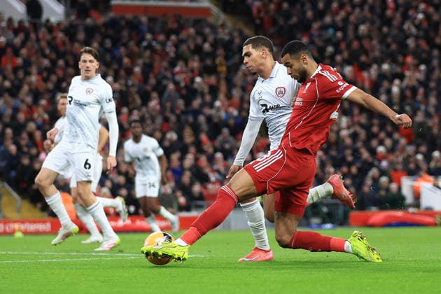 Liverpool, England, 12th January 2026. Cody Gakpo of Liverpool shoots at goal under pressure from Tennai Watson of Barnsley during the Liverpool vs Barnsley FA Cup match at Anfield, Liverpool. Picture credit should read: Jessica Hornby Sportimage EDITORIAL USE ONLY. No use with unauthorised audio, video, data, fixture lists, club league logos or live services. Online in-match use limited to 120 images, no video emulation. No use in betting, games or single club league player publications. SPI_093_JH_Liverpool_Barnsley SPI-4444-0093