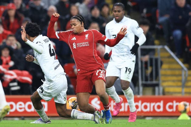 Liverpool, England, 12th January 2026. Rio Ngumoha of Liverpool is challenged by Vimal Yoganathan of Barnsley during the Liverpool vs Barnsley FA Cup match at Anfield, Liverpool. Picture credit should read: Jessica Hornby Sportimage EDITORIAL USE ONLY. No use with unauthorised audio, video, data, fixture lists, club league logos or live services. Online in-match use limited to 120 images, no video emulation. No use in betting, games or single club league player publications. SPI_094_JH_Liverpool_Barnsley SPI-4444-0094