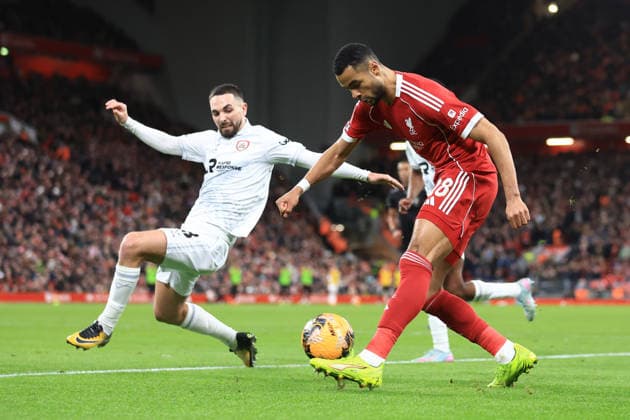 Liverpool, England, 12th January 2026. Cody Gakpo of Liverpool shoots at goal under pressure from Adam Phillips of Barnsley during the Liverpool vs Barnsley FA Cup match at Anfield, Liverpool. Picture credit should read: Jessica Hornby Sportimage EDITORIAL USE ONLY. No use with unauthorised audio, video, data, fixture lists, club league logos or live services. Online in-match use limited to 120 images, no video emulation. No use in betting, games or single club league player publications. SPI_097_JH_Liverpool_Barnsley SPI-4444-0097