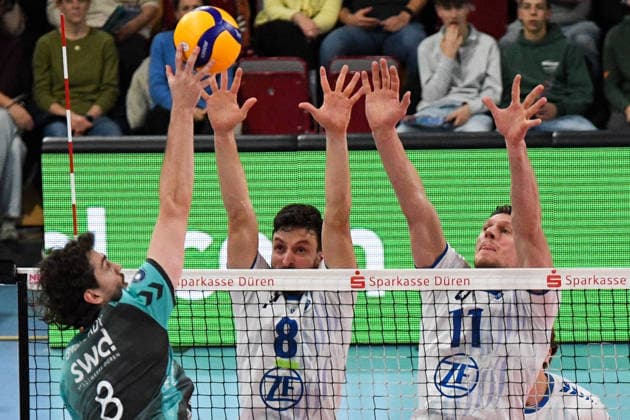 v.li.: Robin Baghdady (Powervolleys Düren, 8) schmettert den Ball, Aleksa Batak (VfB Friedrichshafen, 8) und Marcus Böhme (VfB Friedrichshafen, 11) bei der Blockbildung, , 14.01.2026, Düren (Deutschland), Volleyball, 1. Bundesliga Männer, SWD Powervolleys Düren - VfB Friedrichshafen