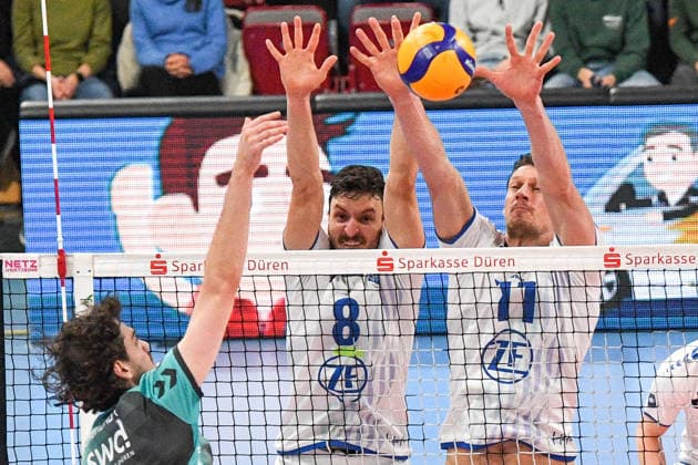 v.li.: Robin Baghdady (Powervolleys Düren, 8) schmettert den Ball, Aleksa Batak (VfB Friedrichshafen, 8) und Marcus Böhme (VfB Friedrichshafen, 11) bei der Blockbildung, , 14.01.2026, Düren (Deutschland), Volleyball, 1. Bundesliga Männer, SWD Powervolleys Düren - VfB Friedrichshafen