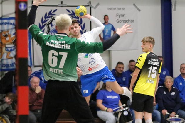 14.01.2026 Handball Herren 2025 2026 Benefizspiel SV Eiche 05 Biederitz - Dessau-Roßlauer HV 06 Ehlesporthalle Biederitz Yannick-Marcos Pust (Dessau, 98, weiß) beim Wurf. Joey Witte (Biederitz, 67, grün) erwartet diesen. Biederitz Sachsen-Anhalt Deutschland