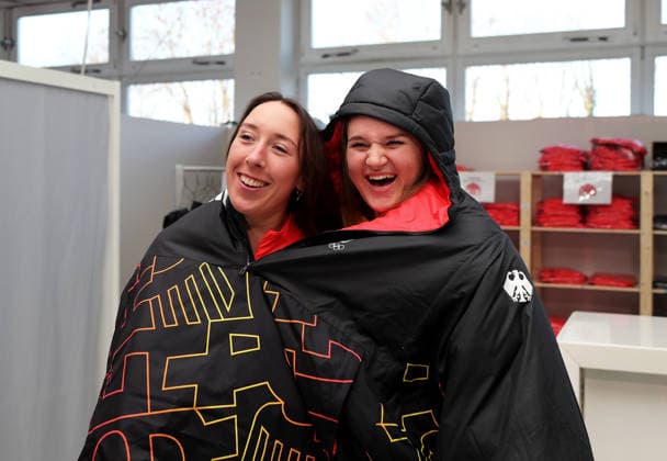 Einkleidung Team Deutschland Olympische Winterspiele, Olympia Hier im Bild Kira Weidle-Winkelmann (li.) mit Emma Aicher (GER) (re.) unter einem Regenponcho, Deutsche Skirennläuferin *** Dressing Team Germany Olympic Winter Games, Olympia Here in the picture Kira Weidle Winkelmann left with Emma Aicher GER right under a rain poncho, German ski racer