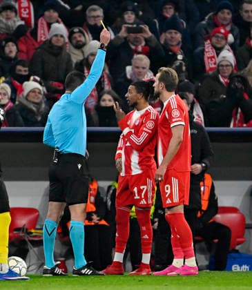21.01.2026, Fussball UEFA Championsleague 2025 2026: Vorrunde 7.Spieltag, FC Bayern München - Union Saint-Gilloise, in der Allianz-Arena München. Referree Rade Obrenovic (SVN) zeigt Michael Olise (FC Bayern München) die gelbe Karte.