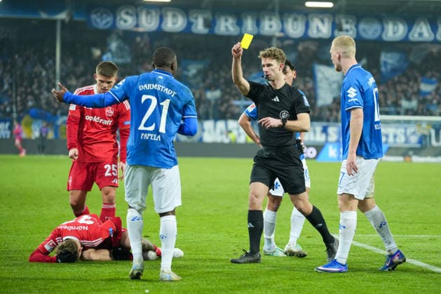 Fussball: 2. Bundesliga, 19. Spieltag, SV Darmstadt 98 - 1. FC Nürnberg am 23.01.2026 in Darmstadt (Merck-Stadion am Böllenfalltor), Deutschland, Saison 2025 2026: DFB DFL REGULATIONS PROHIBIT ANY USE OF PHOTOGRAPHS as IMAGE SEQUENCES and or QUASI-VIDEO: Jarno Wienefeld (Schiedsrichter) zeigt Matondo-Merveille Papela (21, SVD) die Gelbe Karte nach foul an Tim Janisch (32, FCN). Darmstadt Merck-Stadion am Böllenfalltor Deutschland