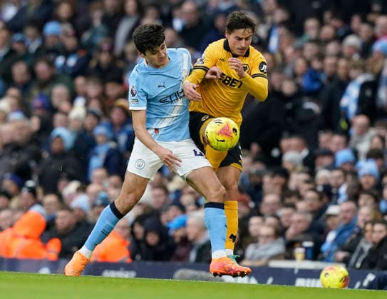 Manchester, England, 24th January 2026. Abdukodir Khusanov of Manchester City (L) challenges Hugo Bueno of Wolverhampton Wanderers during the Manchester City vs Wolverhampton Wanderers Premier League match at the Etihad Stadium, Manchester. Picture credit should read: Andrew Yates Sportimage EDITORIAL USE ONLY. No use with unauthorised audio, video, data, fixture lists, club league logos or live services. Online in-match use limited to 120 images, no video emulation. No use in betting, games or single club league player publications. SPI_013_AY_MAN_CITY_WOLVES SPI-4473-0013