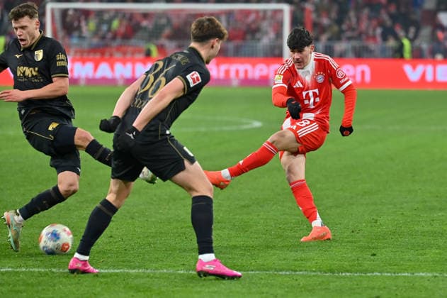 GER, Bayern, Muenchen, Fussball, FC Bayern Muenchen - FC Augsburg, in der Allianz Arena, Muenchen, Bundesliga, 19. Spieltag, 24.01.26, v.l. Mert Koemuer (FC Augsburg, 36), Felipe Chavez (FC Bayern, Muenchen, 38), Torschuss DFL DFB regulations prohibit any use of photographs as image sequences and or quasi-video, Copyright: HMB-Media MichaelxNibel