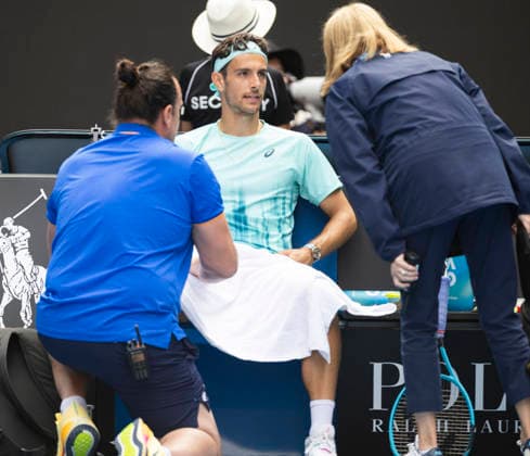 (260128) -- MELBOURNE, Jan. 28, 2026 -- Lorenzo Musetti (C) of Italy receives medical treatment during the men s singles quarterfinal match between Novak Djokovic of Serbia and Lorenzo Musetti of Italy at the Australian Open tennis tournament in Melbourne, Australia, Jan. 28, 2026. (Photo by Xinhua) (SP)AUSTRALIA-MELBOURNE-TENNIS-AUSTRALIAN OPEN-MEN S SINGLES-QUARTERFINALS HuxJingchen 