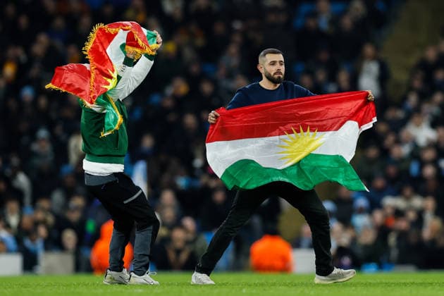 Manchester, England, 28th January 2026. Pitch invaders hold up the Kurdistan flag during the Manchester City vs Galatasaray UEFA Champions League match at the Etihad Stadium, Manchester. Picture credit should read: Andrew Yates Sportimage EDITORIAL USE ONLY. No use with unauthorised audio, video, data, fixture lists, club league logos or live services. Online in-match use limited to 120 images, no video emulation. No use in betting, games or single club league player publications. SPI_039_CF_Man_City_Galatasaray SPI-4489-0096