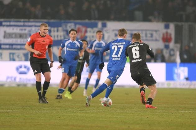 Magdeburg, Sachsen-Anhalt, Deutschland, 30.01.2026: Avnet Arena: 20. Spieltag, Saison 2025 26, 2. Fußball-Bundesliga: 1. FC Magdeburg - Hannover 96: Philipp Hercher (27, 1. FC Magdeburg) und Maik Nawrocki (06, Hannover 96) duellieren sich vor den strengen Augen von Schiedsrichter Timo Gansloweit