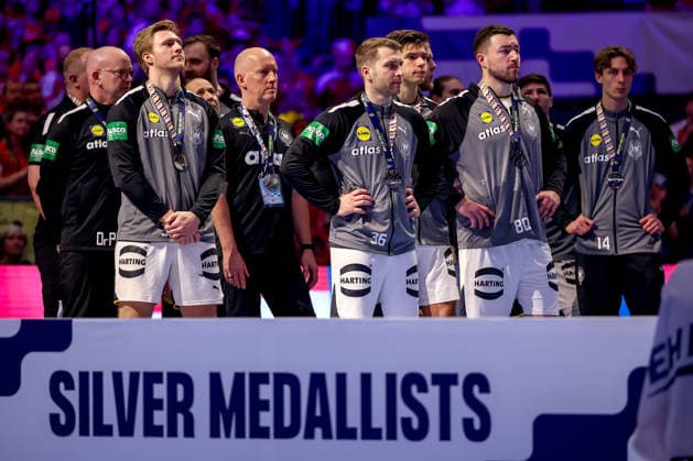 01.02.2026, Handball, Men s EHF EURO 2026, Deutschland - Dänemark, Jyske Bank Boxen in Herning, Final: Dänemark ist Europameister. Die Mannschaft feiert den Sieg jubelnd auf dem Spielfeld. Das Deutsche Team (Silver Medallist) steht enttäuscht Enttäuschung neben der Siegerehrung und schaut den Dänen beim Jubeln zu. Dänemark
