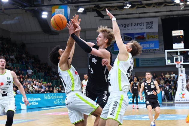 21. Spieltag der Basketball 2. Bundesliga ProA in der Oberfrankenhalle in Bayreuth Saison 2025-2026 BBC Bayreuth gegen Nürnberg Falcons BC Louis Nauthon (BBC Bayreuth) -51- links Lenny Liedtke (BBC Bayreuth) -55- rechts Trevor Baskin (Nürnberg Falcons BC) -22- mitte