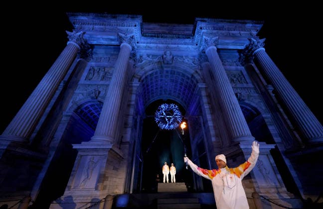 (260207) -- MILAN, Feb. 7, 2026 -- Torchbearers Enrico Fabris (front) passes the Olympic flame during the opening ceremony of the Milan-Cortina 2026 Olympic Winter games, Winterspiele,Spiele, Summer games at the Arco della Pace in Milan, Italy, Feb. 6, 2026. ( Pool via Xinhua) (MICO2026)ITALY-MILAN-CORTINA 2026-OLYMPIC WINTER GAMES-OPENING CEREMONY JamiexSquire 