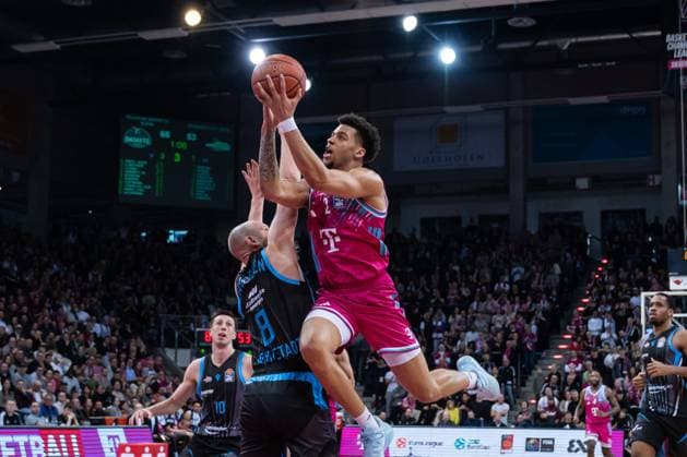 Spielaktion mit Alijah Comithier (2; Telekom Baskets Bonn) mit Wurf und Joe Wieskamp (10; Science City Jena) und Robin Christen (8, Science City Jena) in der Verteidigung im TelekomDome in der EasyCredit BBL am 19. Spieltag in Bonn. Alijah Comithier (2; Telekom Baskets Bonn) mit Wurf gegen Joe Wieskamp (10; Science City Jena) und Robin Christen (8, Science City Jena)