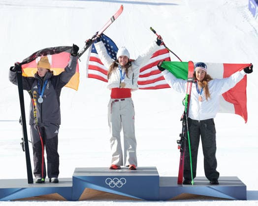 L-R Germany s Emma Aicher, USA s Breezy Johnson (C) and Italy s Sofia Goggia celebrate their medals in the Women s downhill race at the 2026 Winter Olympics in Cortina, Italy on Sunday February 08, 2026. USA s Lndsey Vonn crashed at the top of the course and was airlifted to hospital.  OLY2026020814 HUGOxPHILPOTT