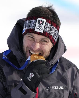 Milan Cortina Olympics: Snowboarding Benjamin Karl of Austria bites his gold medal after winning the snowboarding men s parallel giant slalom at the Milan Cortina Olympics at Livigno Snow Park in Livigno, Italy, on Feb. 8, 2026.  A14AA0005256792P
