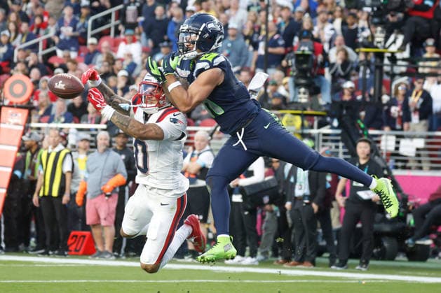 New England Patriots cornerback Christian Gonzalez left, breaks up the reception by Seattle Seahawks wide receiver Jaxon Smith-Njigba, right, during the second quarter of Super Bowl LX at Levi s Stadium in Santa Clara, California on Sunday, February 8, 2026.  SBP20260208151 JOHNxANGELILLO